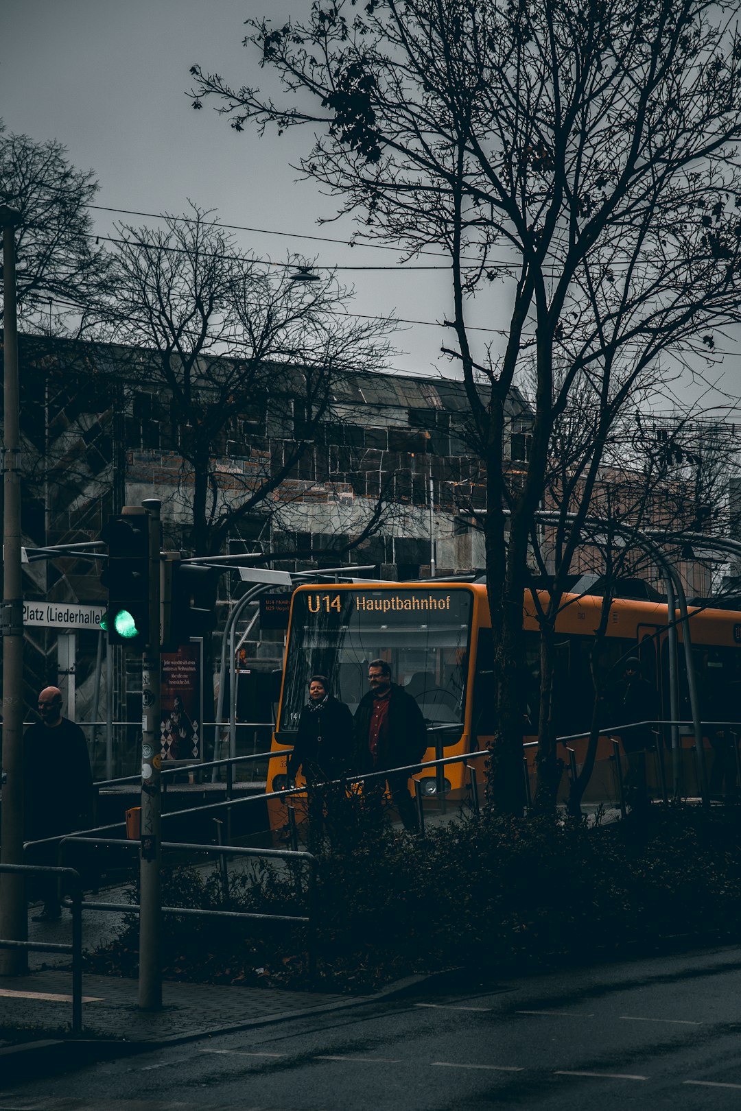 people walking near bus, buildings, and trees during day