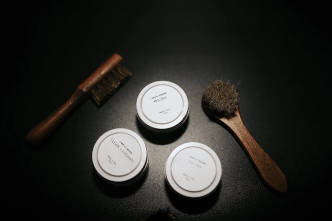Close-up of premium horse grooming brushes arranged neatly on a wooden table.