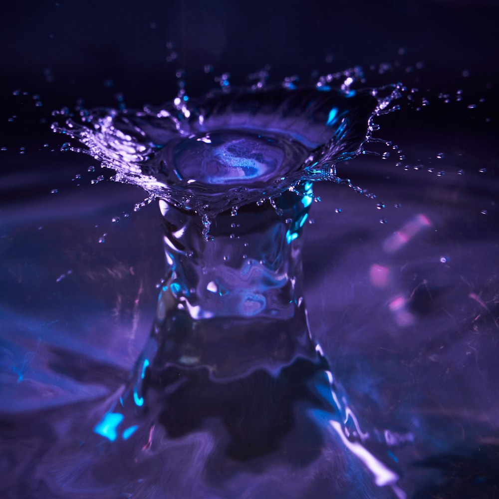 a purple and blue liquid splashing into the water
