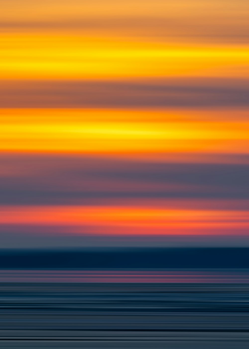 a large body of water with a sky in the background