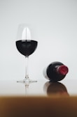 half-filled wine glass beside bottle