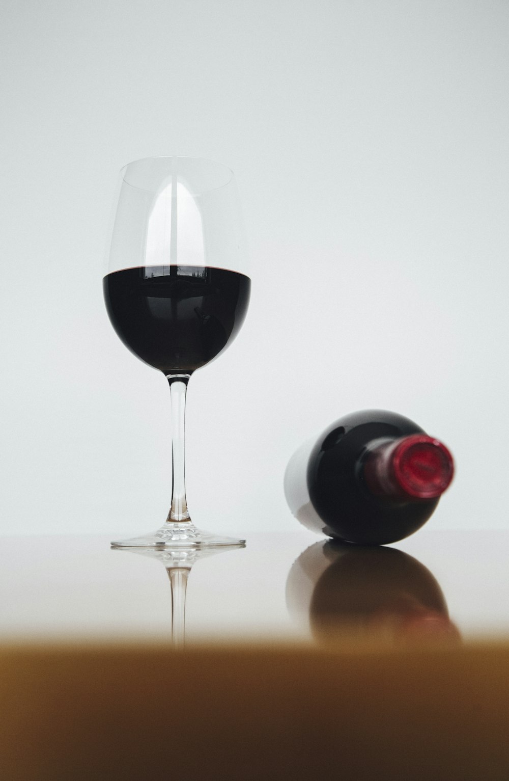 half-filled wine glass beside bottle