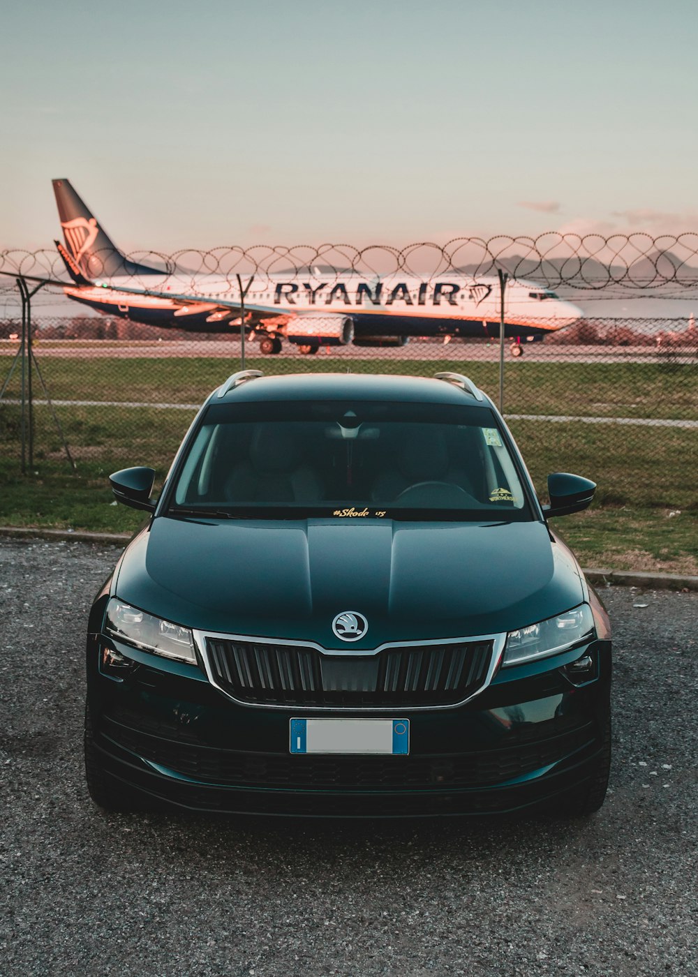 black Skoda vehicle parked near airplane