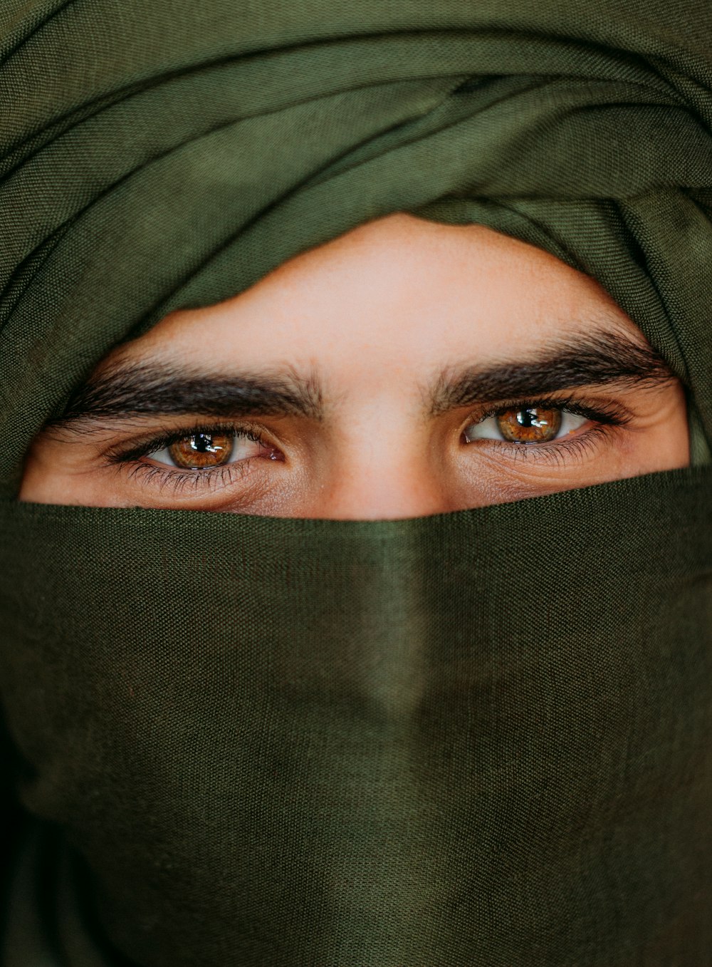 a close up of a person wearing a green head scarf