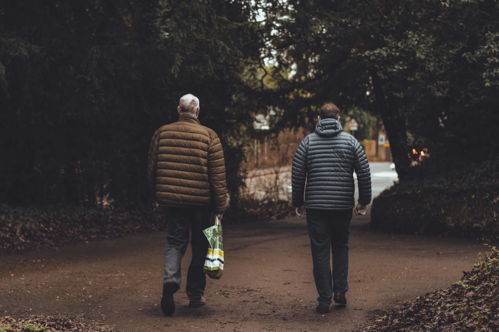 Two men walking together along a road, deep in conversation
