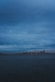 city buildings near body of water under cloudy sky
