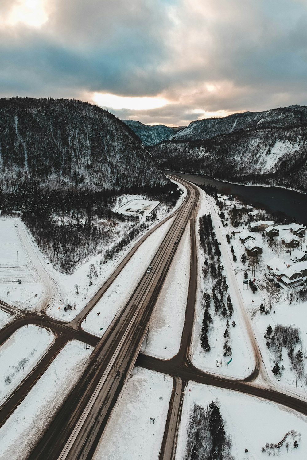 estrada perto do rio e montanha coberta de neve durante o dia