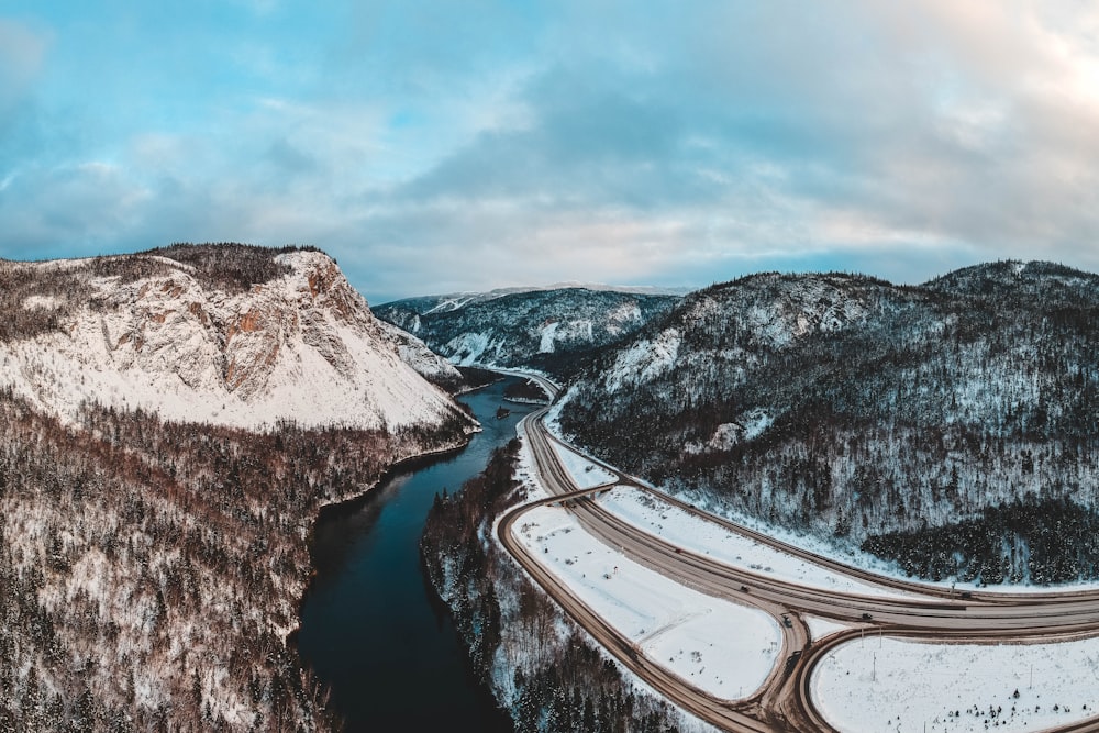 road near river and mountain during daytime