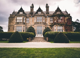 low-angle photography of brown mansion under a cloudy sky during daytime
