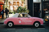 a pink car parked in front of a store