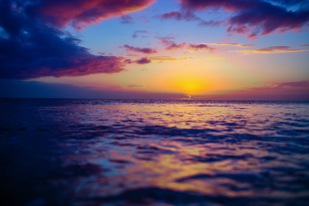 sea under cloudy sky during golden hour