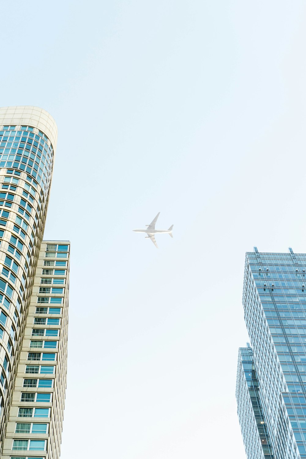 airplane flying above high-rise buildings