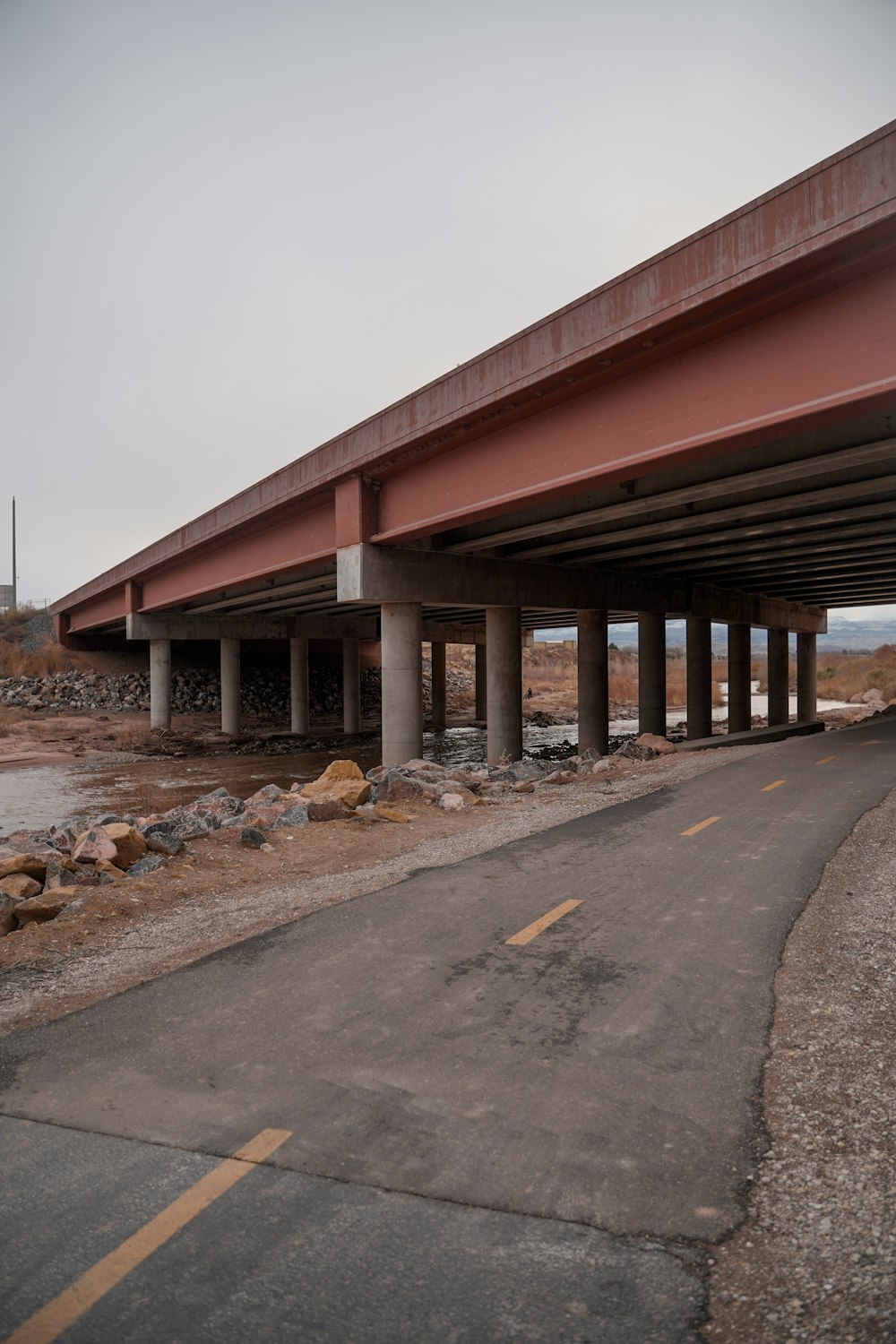 concrete bridge above road and body of water