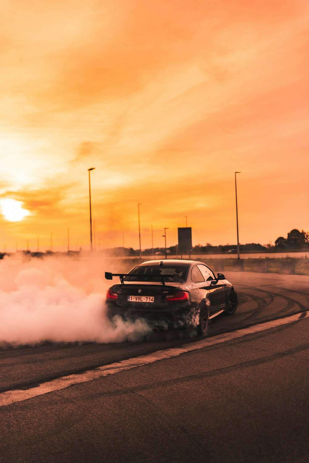 black car drifting on road during day