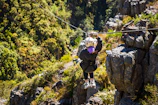 Adventurers zipping across the flying fox with the dense jungle canopy below.