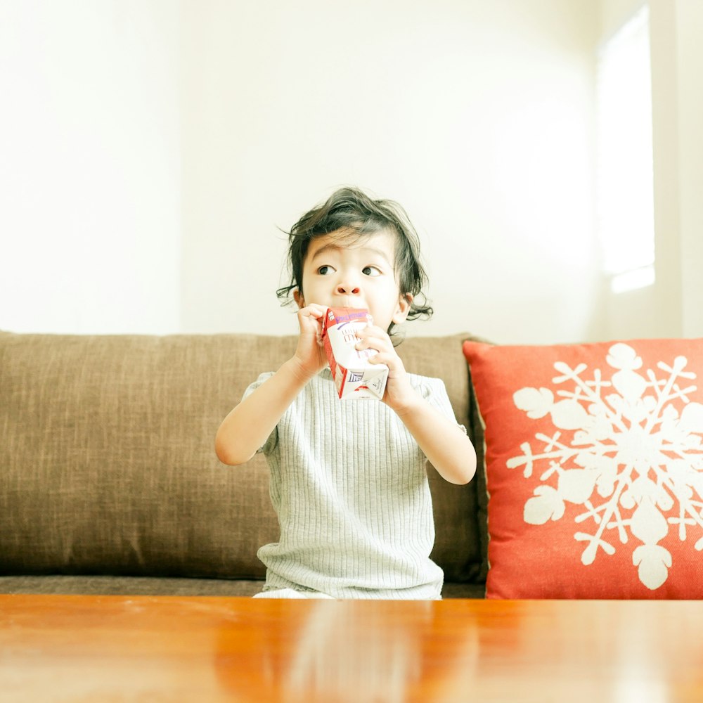 boy sitting on sofa and drinking from juicebox
