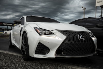 A sleek, high-performance sports car poised on the Nürburgring starting grid under a dramatic sky.