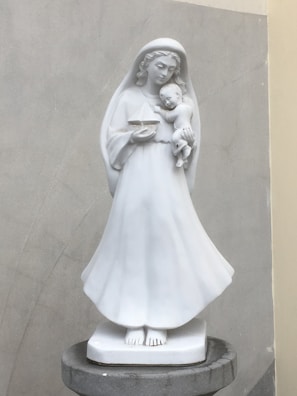 A serene marble figure symbolizing maternal care, reflecting early 20th-century Swedish design.