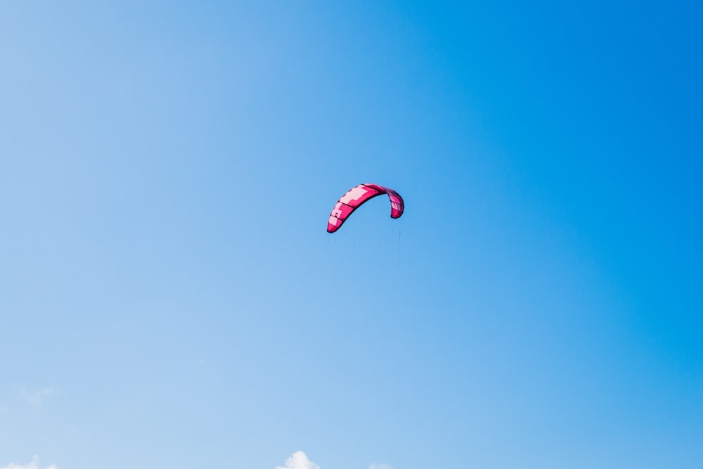 person paragliding under white and blue sky