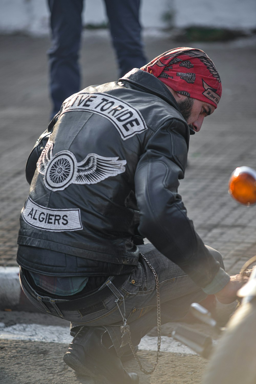 man taking a knee beside motorcycle