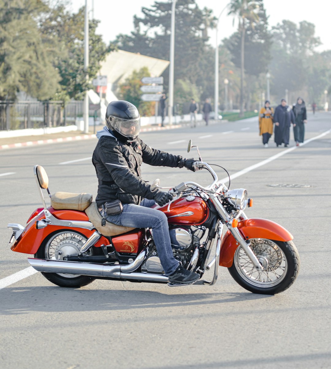 man riding motorcycle on road near people during day