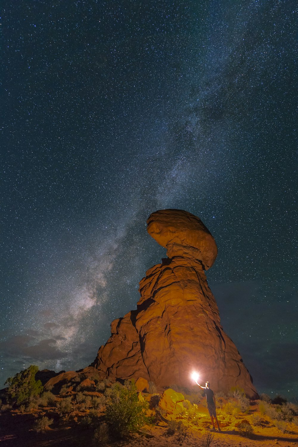 person holding light near mountain during night