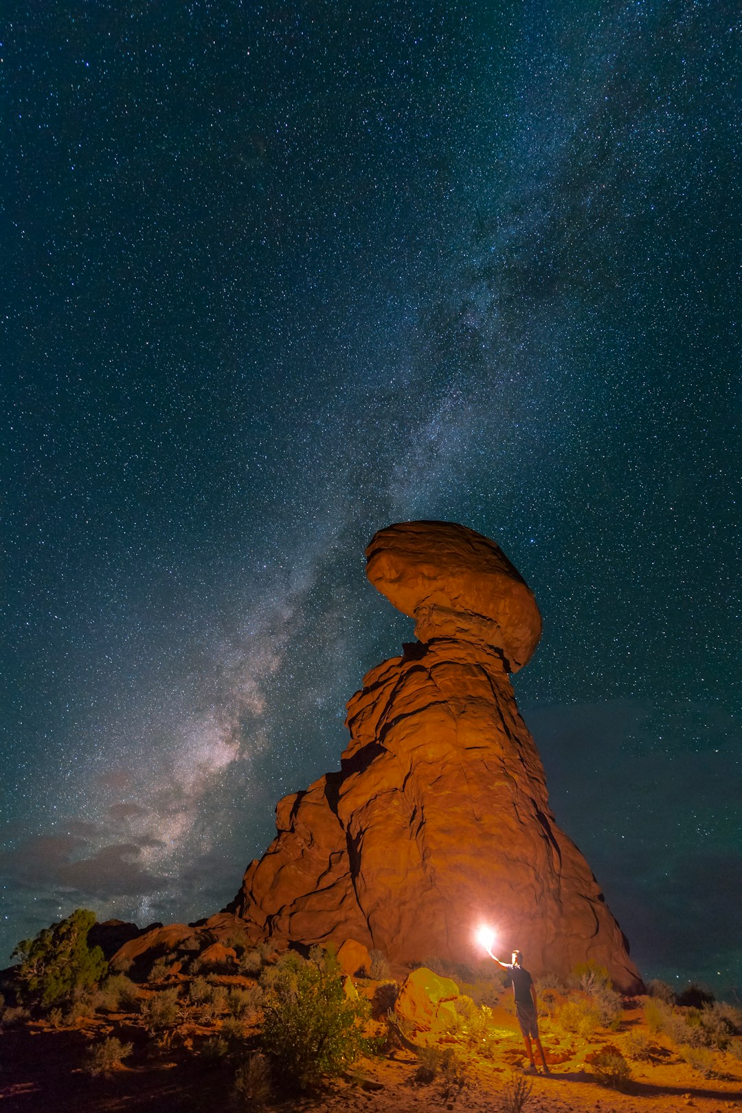 person holding light near mountain during night