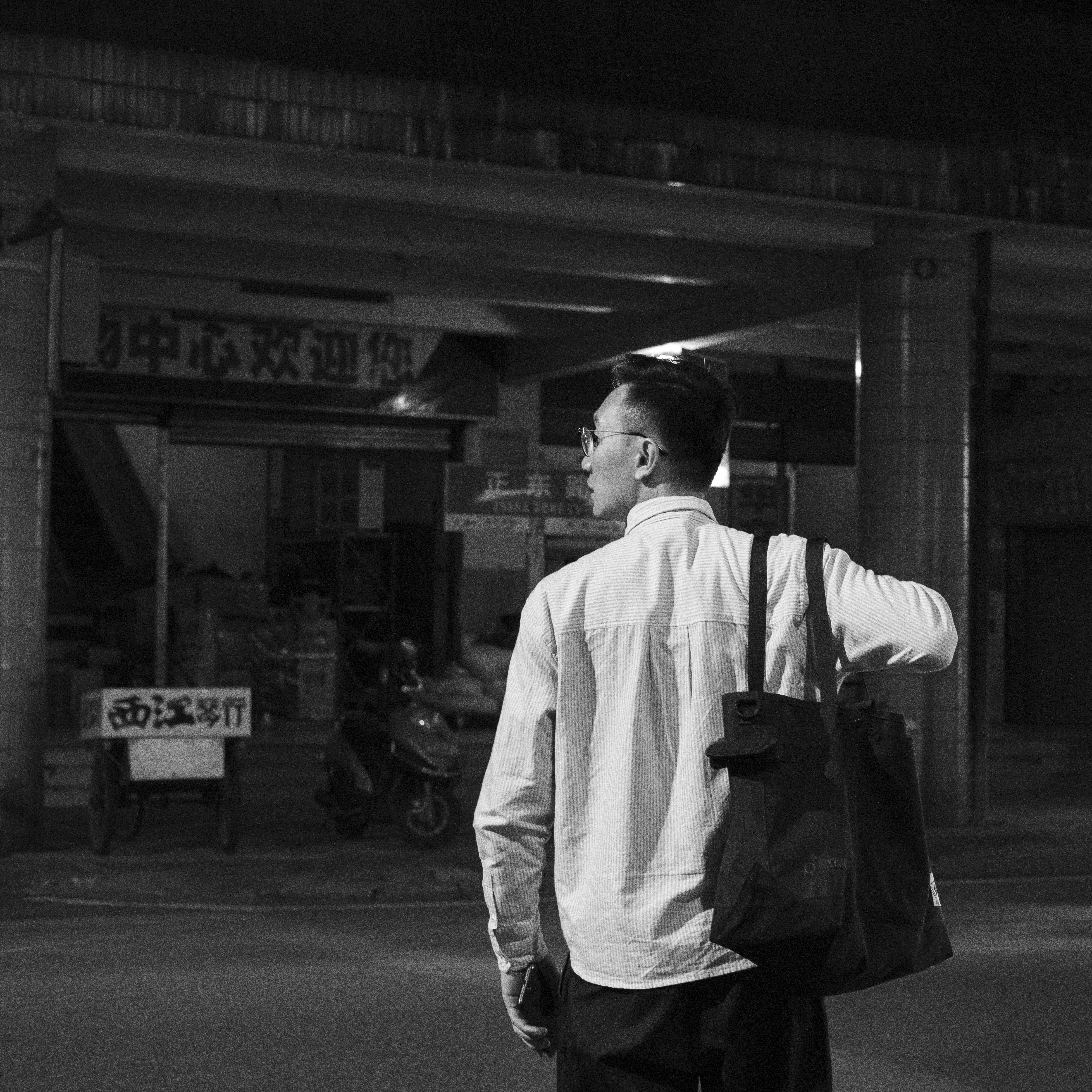 Grayscale photography of man carrying a tote bag photo Free Grey