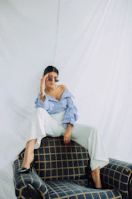 Lifestyle shot of a confident woman wearing a co-ord set, seated comfortably in a modern heritage home with soft linen curtains and natural sunlight.