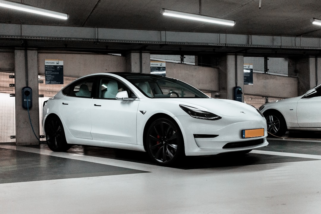 shallow focus photo of white sedan, White Tesla charging...