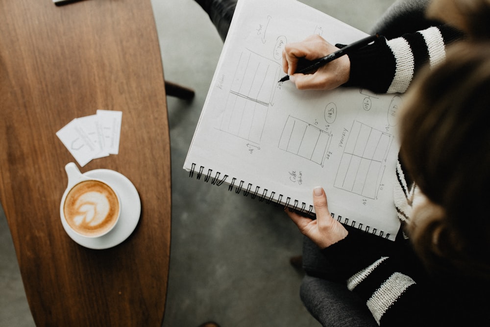 woman drawing on spiral book