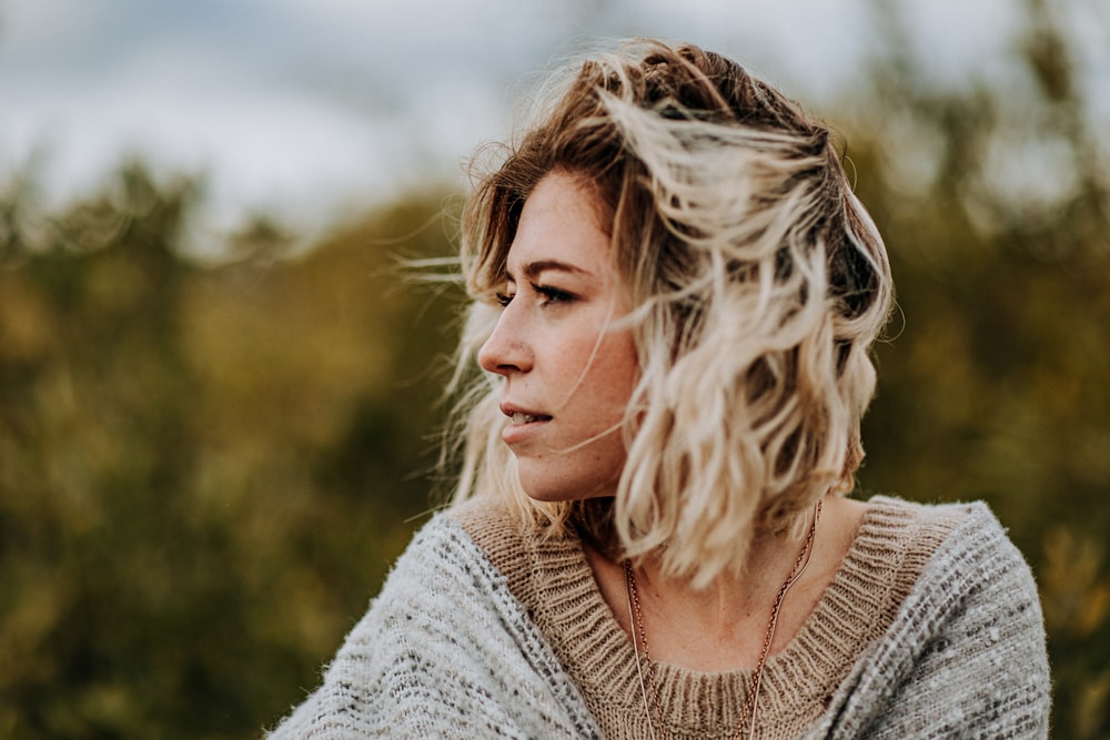 woman wearing brown sweater glancing her right side