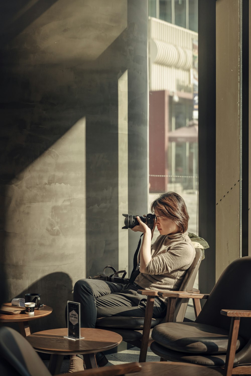 sitting woman using DSLR camera inside room