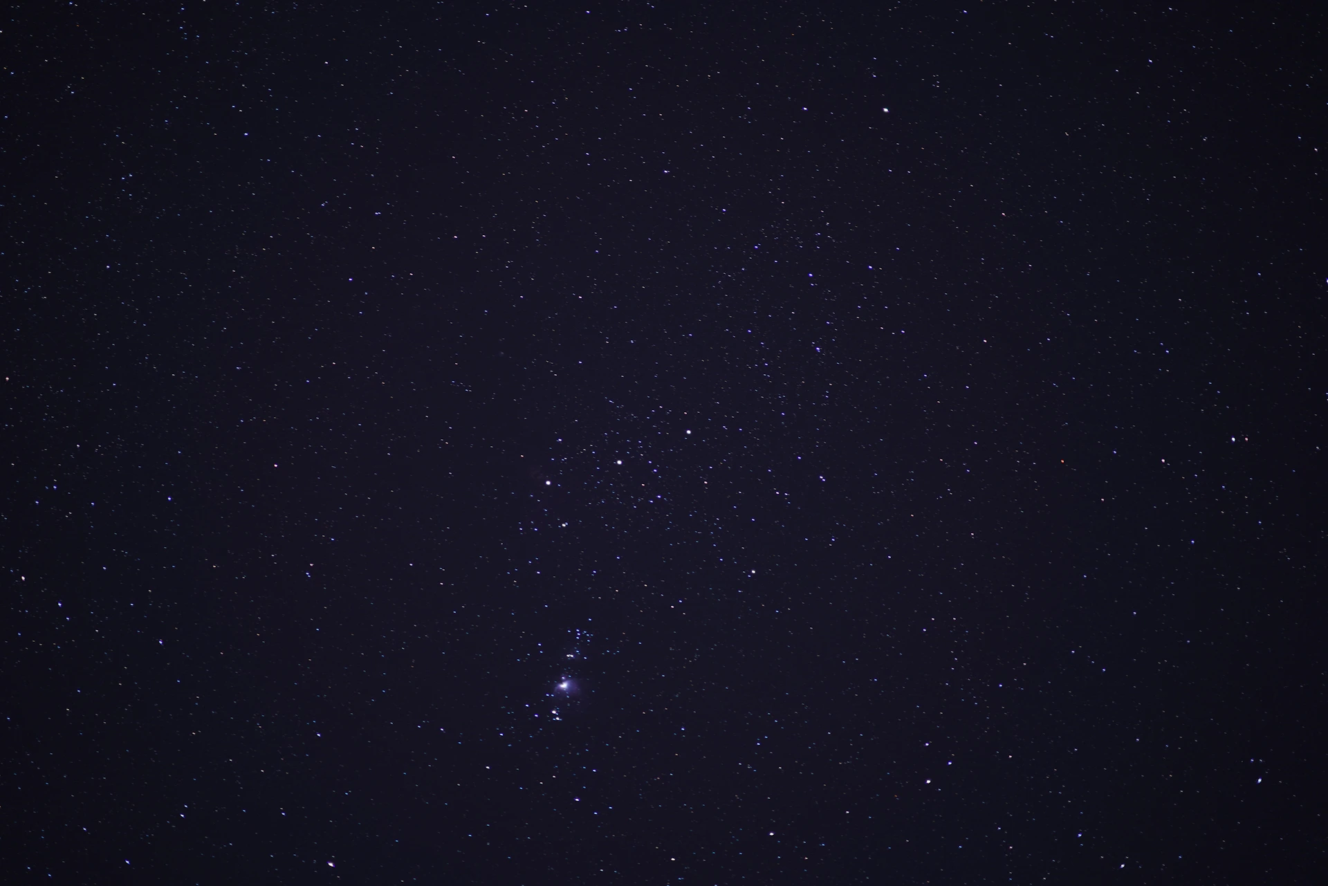 a night sky with stars and a few clouds