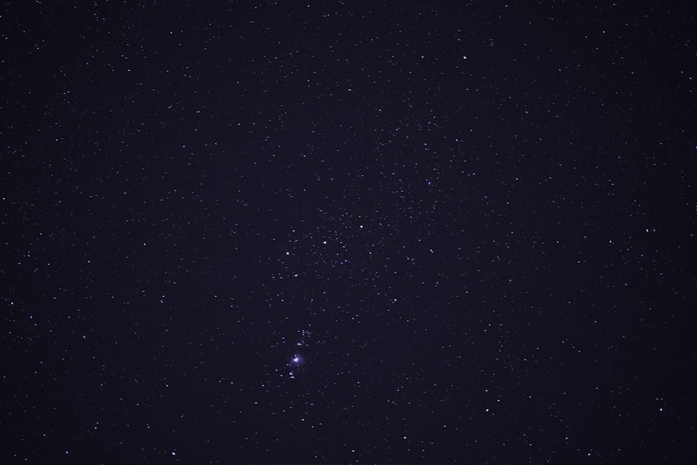 a night sky with stars and a few clouds