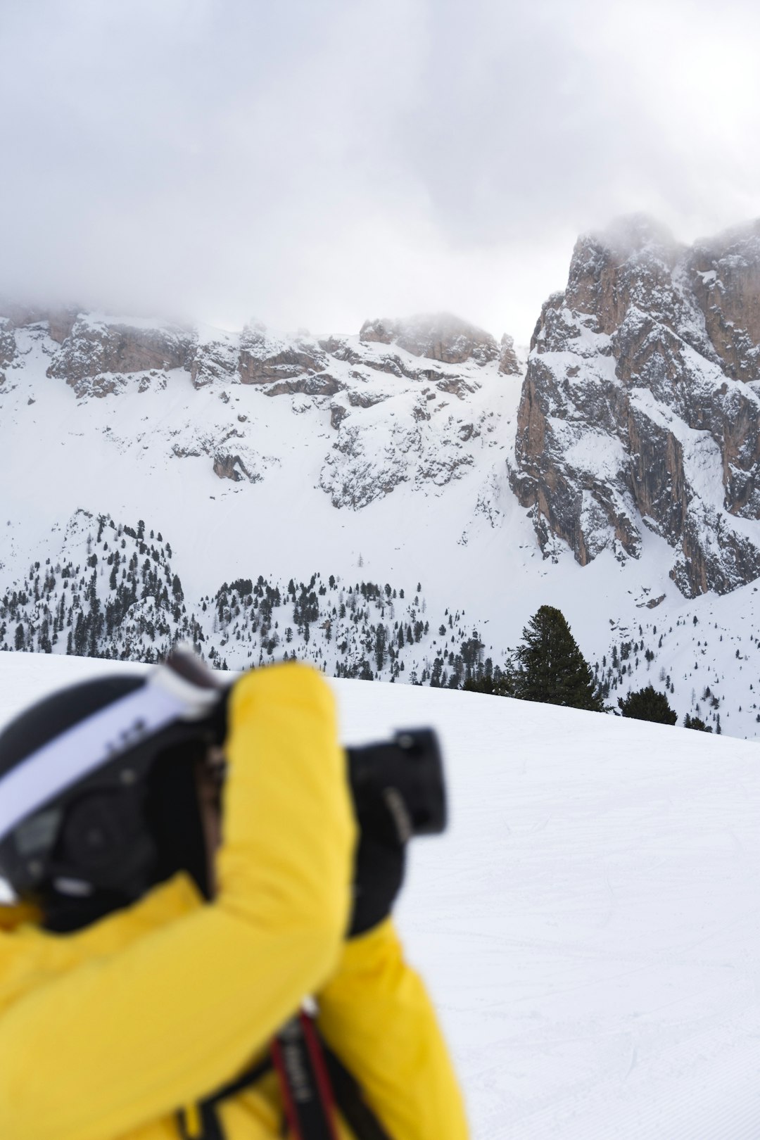 man in yellow jacket standing on snow mountain