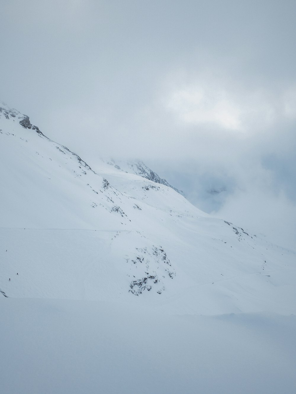 montanhas cobertas de neve sob nuvens pesadas