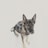 A German Shepherd wearing a harness with the label 'Non-stop' is sitting on a snowy surface. The dog's ears are perked up, and it appears alert and attentive. The fur is a mix of black and tan colors, with a focused expression on its face.