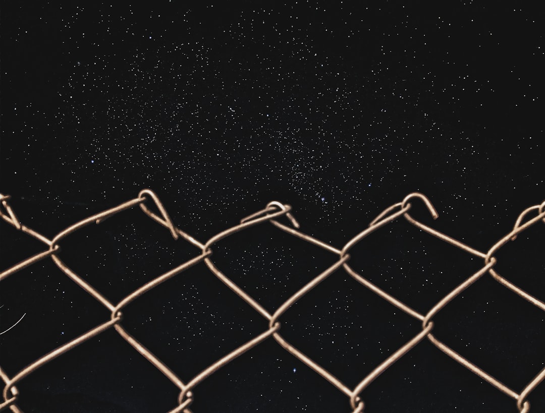 gray chain link fence at night