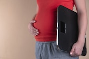 pregnant woman touching her belly and carrying a digital bathrooms cale