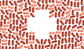 Close-up of a healthy heart illustration with omega-3 capsules around it.