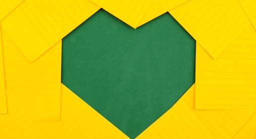 yellow papers forming green heart hole
