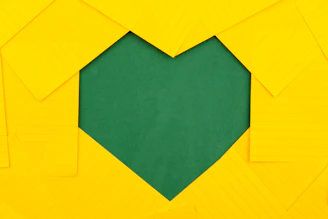 yellow papers forming green heart hole