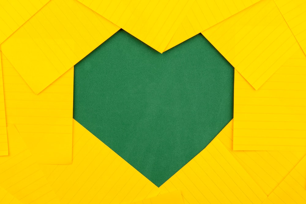 papéis amarelos formando buraco de coração verde
