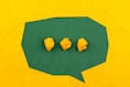 three crumpled yellow papers on green surface surrounded by yellow lined papers