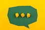 three crumpled yellow papers on green surface surrounded by yellow lined papers