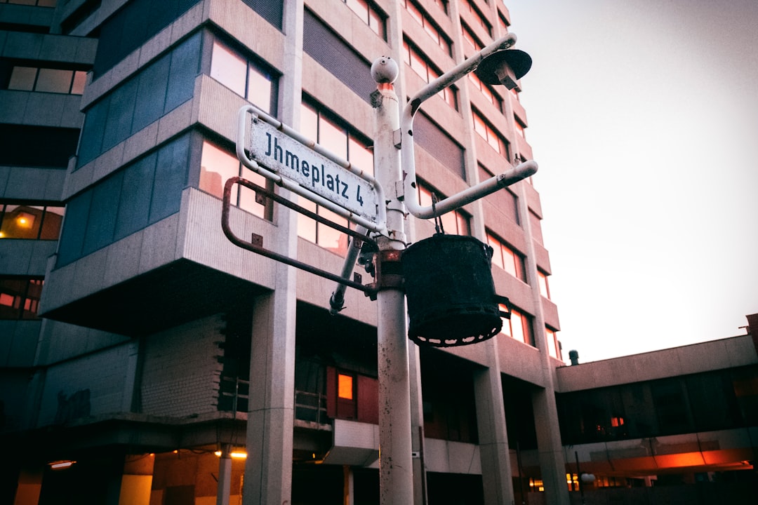 post with lamp and signboard near building during day