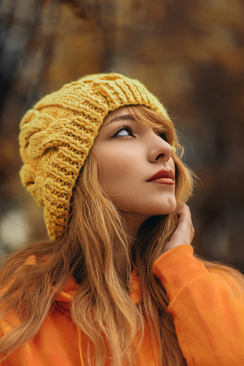 woman in yellow beanie hat and orange sweatshirt