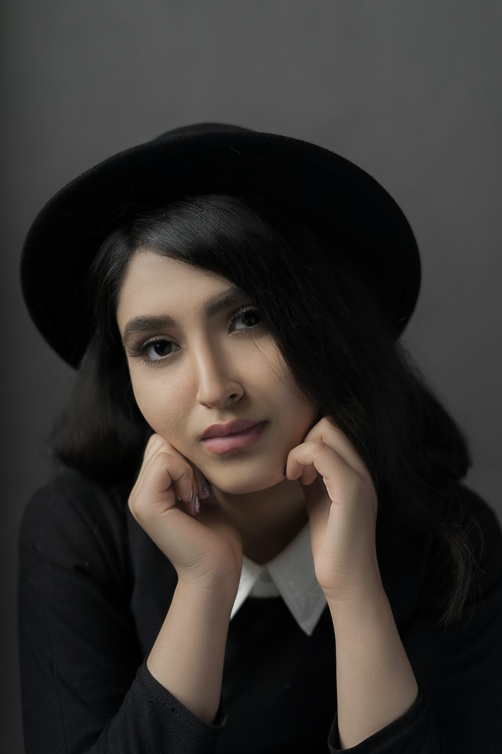 woman in black and white collared top and black hat