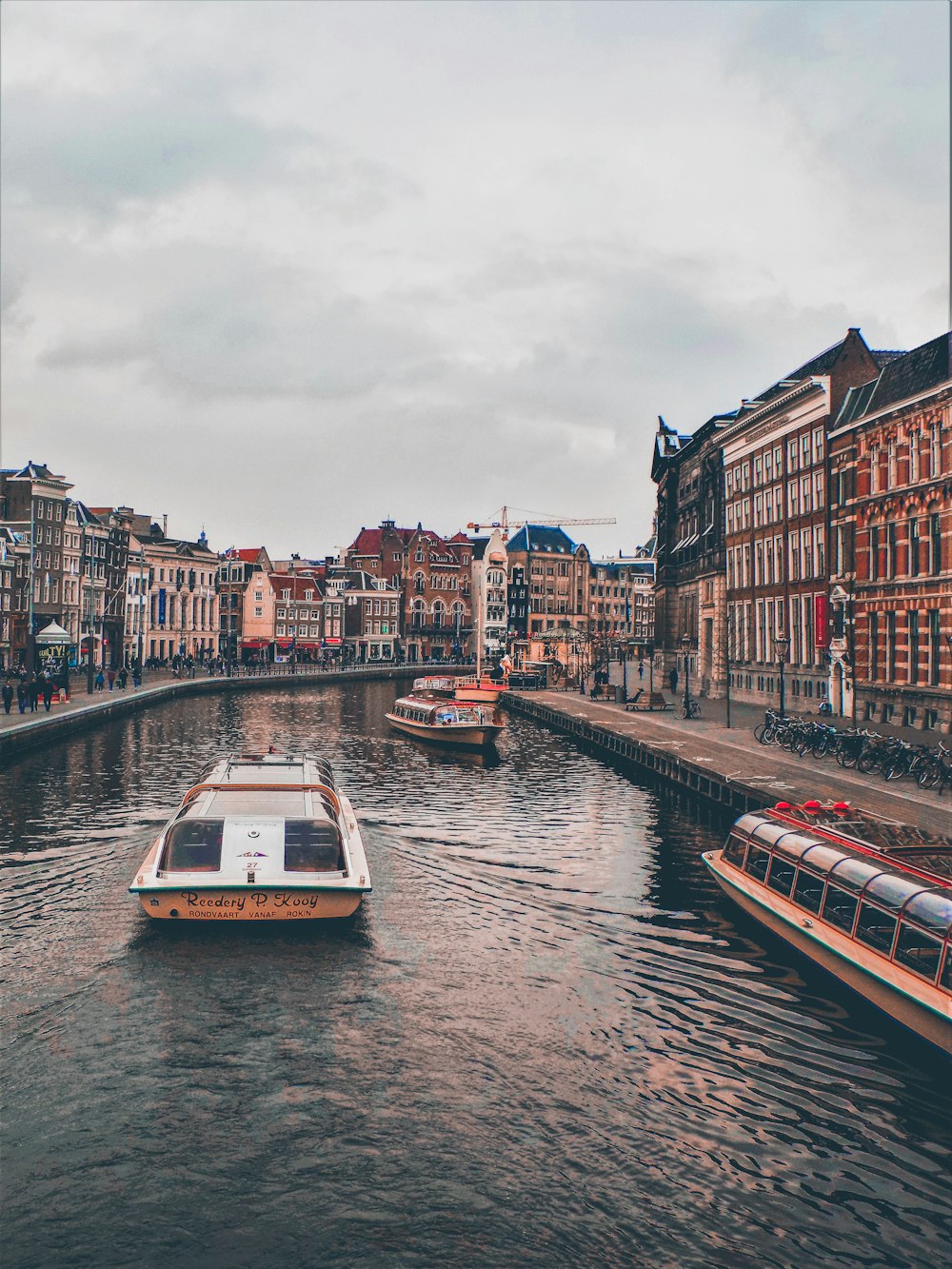 boats in body canal between buildings